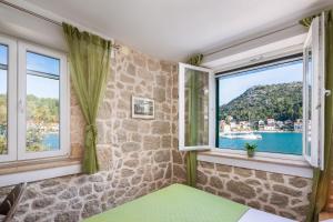 a bedroom with windows and a view of the water at Adriatic Sunrise - Beach House in Blace