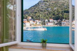 a window with a view of a bay with boats at Adriatic Sunrise - Beach House in Blace +100 photos