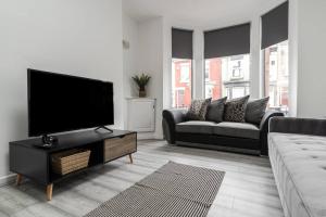 a living room with a flat screen tv and a couch at Liverpool 3 bed house (free parking) in Liverpool