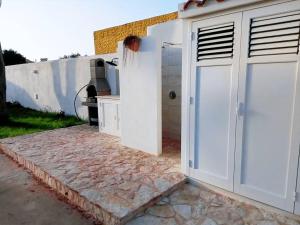 uma garagem com portas brancas num pátio em VILLA DAIANA em Lampedusa