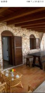 Cette chambre dispose d'une table et d'un mur en pierre. dans l'établissement VILLA DAIANA, à Lampedusa