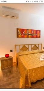 VILLA DAIANA في لامبيدوسا: غرفة نوم بسرير وطاولة ولوحة