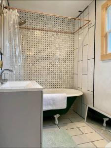 a bathroom with a bath tub and a sink at Studio Apt w Garden in Kingston