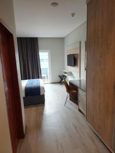 ein Hotelzimmer mit einem Bett und einem Schreibtisch in der Unterkunft 12 Oceans Hotel and Conference Centre in Kingsborough