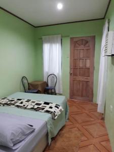 Schlafzimmer mit einem Bett und einer Holztür in der Unterkunft Susing Seaside Guesthouse in Moalboal