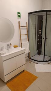 a bathroom with a sink and a shower with a mirror at Apartamento Pérola da Vila in Vila Franca do Campo