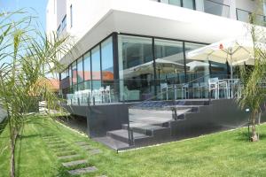 a glass building with tables and chairs in it at Hotel Monte Lírio in Espinho