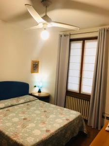ヴェローナにあるCasa Martini Piazza Erbeのベッドルーム1室(ベッド1台、シーリングファン付)