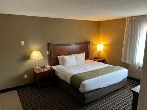 a hotel room with a large bed with two lamps at Quality Inn & Suites Bradford in Bradford