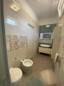 a bathroom with a white toilet and a sink at Romantica in Brindisi +27 photos