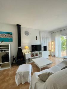 ein Wohnzimmer mit einem Sofa und einem Tisch in der Unterkunft Casa con piscina Sant Pol de Mar in San Pol de Mar