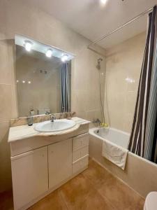 a bathroom with a sink and a mirror and a tub at Casa con piscina Sant Pol de Mar in San Pol de Mar