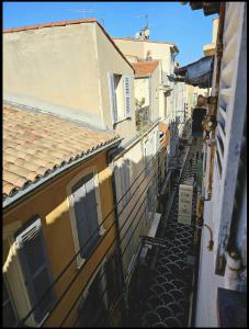 een steegje tussen twee gebouwen in een stad bij Appartement sous les toits in Antibes