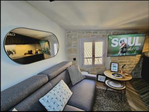 sala de estar con sofá y espejo grande en Appartement sous les toits en Antibes