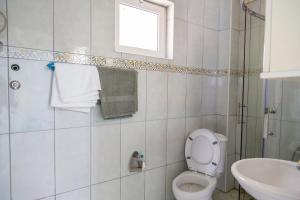 a bathroom with a toilet and a sink and a window at Villa Erik in Ulcinj