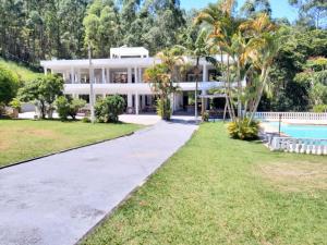 an exterior view of a large white house with a swimming pool at SÍTIO FLOR DE LYS in Jarinu
