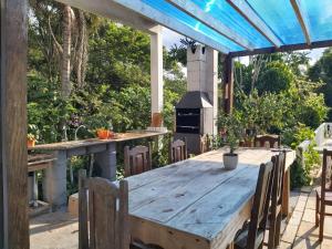 a wooden table and chairs on a patio with a stove at SÍTIO FLOR DE LYS in Jarinu