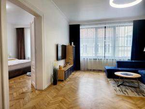uma sala de estar com um sofá azul e uma cama em SbOldTown Apartament em Brasov