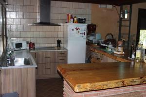 a kitchen with a white refrigerator and a sink at CORTIJO HOYA MESA in Santa Fe