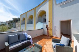 Eine Frau steht auf dem Balkon eines Hauses in der Unterkunft Albadamare Boutique Hotel in Praiano