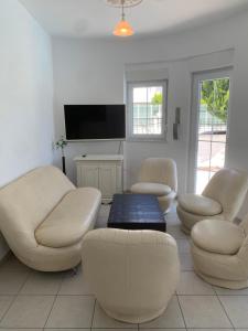 a living room with white furniture and a tv at Belek Villa in Belek