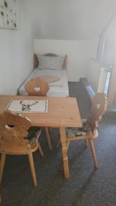 a wooden table with two chairs and a bed at Gasthof zum Hirsch 