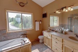 ein Badezimmer mit einer Badewanne, einem Waschbecken und einem WC in der Unterkunft Luxury Leech Lake Home 15 Minutes to Walker in Walker