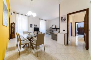a dining room and living room with a table and chairs at [Casa vacanze “In Centro”] in Salerno