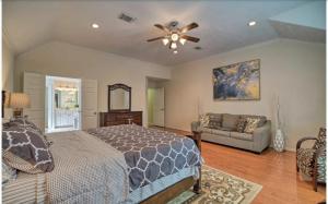 a bedroom with a bed and a couch and a ceiling fan at River Oaks 4BD Home Walkable to Whole Foods & Eateries in Houston