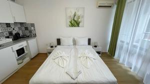 Cama blanca en habitación con cocina en CHATEAU DEL MAR C31a Studio Sunny Beach, en Sunny Beach