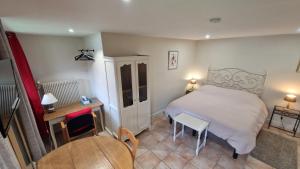 1 dormitorio con 1 cama, mesa y sillas en Gîte de la Noyelle à Sainghin en Mélantois en Sainghin-en-Mélantois
