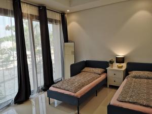1 dormitorio con 2 camas y ventana en Laguna Apartment HAWANA SALALAH Resort en Salalah