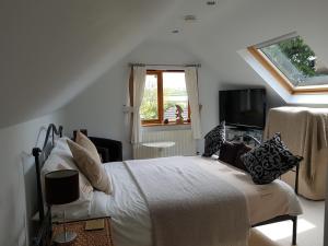 a white bedroom with a bed and a tv at Meadow Oak Accommodation in Bodmin