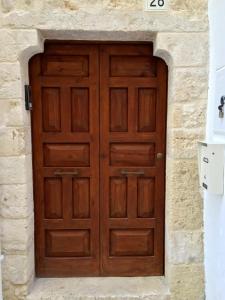 a large wooden door in a stone wall at The Nest / Il Nido in Polignano a Mare