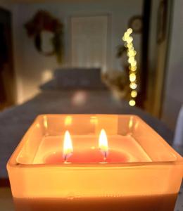 Una vela está sentada en una mesa junto a una cama en Log home village en Ulverston