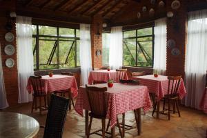 a restaurant with red and white tables and windows at Pousada Quinta do Barao in Conceição da Ibitipoca