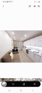 a white living room with a couch and a kitchen at VIP APARTMENTs in Luts'k