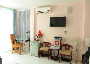 a living room with a table and a tv on the wall at Thao Nhi Hotel in Ho Chi Minh City