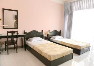 1 dormitorio con 2 camas, escritorio y silla en Thao Nhi Hotel, en Ho Chi Minh
