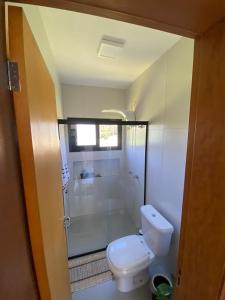a bathroom with a toilet and a shower at Casa de hóspede Dunas do Siriú in Garopaba