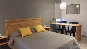 ein Schlafzimmer mit einem Bett mit gelben Kissen und einem Schreibtisch in der Unterkunft Los Aromos in Federación