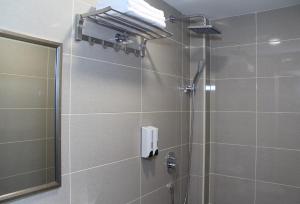uma casa de banho com um chuveiro e uma porta de vidro em Xpeed Holiday Hotel em Kuala Lumpur