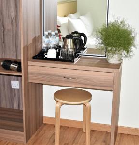 a dressing table with a stool and a mirror at Xpeed Holiday Hotel in Kuala Lumpur