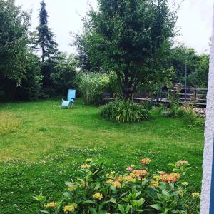 einem blauen Stuhl, der mitten im Hof sitzt in der Unterkunft Meerzeit & Ayurveda in Kirchdorf