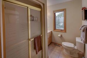 a bathroom with a shower and a toilet and a window at Dog Friendly Leech Lake Home w Perfect Beach Garage Boat Lift in Walker