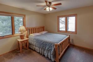a bedroom with a bed and a ceiling fan at Dog Friendly Leech Lake Home w Perfect Beach Garage Boat Lift in Walker