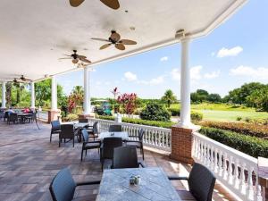a patio with tables and chairs and a view of the golf course at Reunion Resort pool home with hot tub / 4 bedrooms in Kissimmee