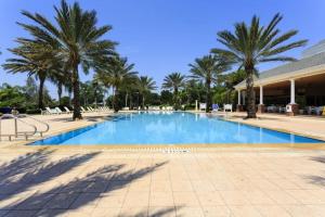 a large swimming pool with palm trees in a resort at Reunion Resort pool home with hot tub / 4 bedrooms in Kissimmee