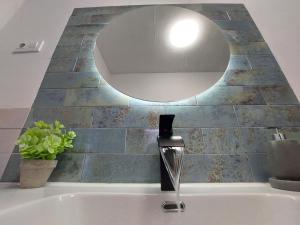 a bathroom sink with a mirror on the wall at apartamentos fuente nueva sande in Cáceres