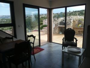 a dining room with a table and chairs and a large window at Domaine Castelsec in Roquefort-des-Corbières